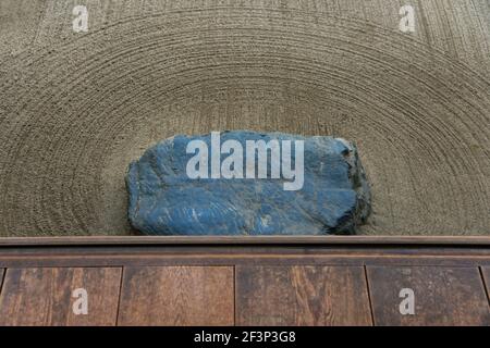 A detailed view shows a shoe-removing stone in the carefully raked sand below the wooden engawa veranda at the edge of the Zen garden inside Shisendo Stock Photo