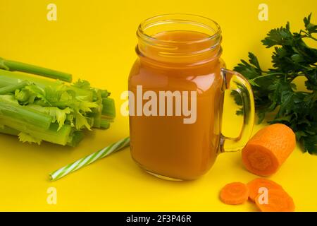 Juice with celery and carrot  on the  yellow background Stock Photo