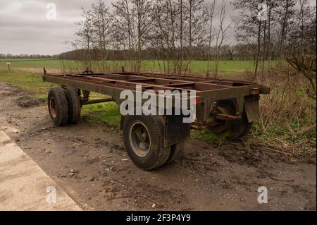 Farmers rusty trailer left on a corner of a field in rural Norfolk Stock Photo