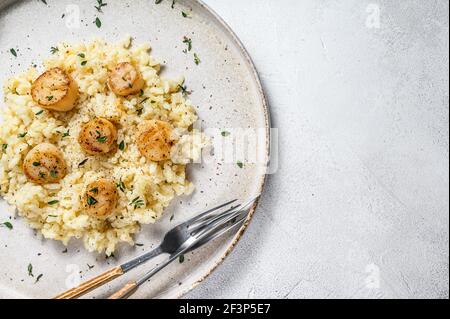 Italian Risotto with pan seared sea scallops. White background. Top view. Copy space Stock Photo