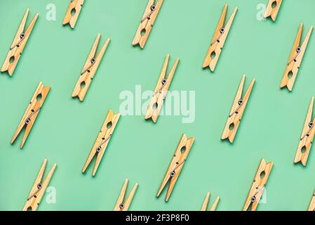 Top view of creative pattern made of wooden clothespins on a green background Stock Photo