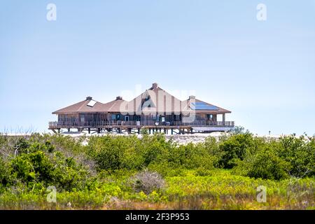 One brown stilted vacation houses on stilts at oceanfront of Atlantic ocean beach at Palm Coast, Florida with renewable solar panels for electricity p Stock Photo