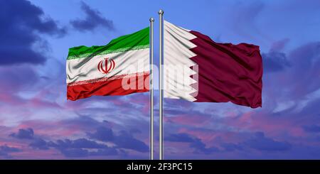 Qatar and Iran flag waving in the wind against white cloudy blue sky together. Diplomacy concept, international relations Stock Photo