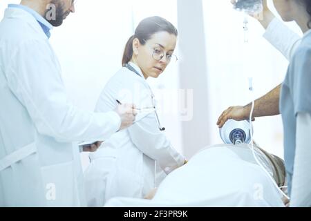 Group of doctors in uniform working in reanimation room at hospital Stock Photo