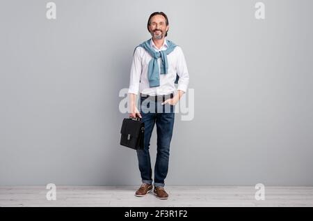 Full length body size photo of businessman wearing white shirt keeping leather bag isolated on pastel grey color background Stock Photo
