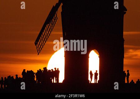 Groups of people watch sunset by Chesterton Windmill in Warwickshire. Picture date: Wednesday March 17, 2021. Stock Photo