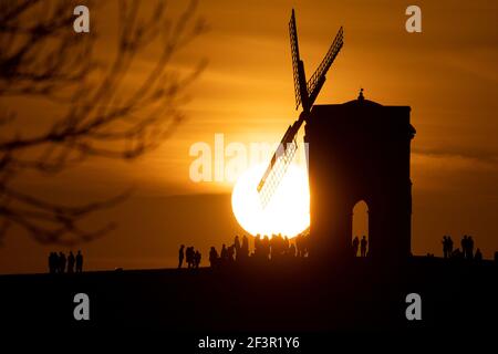 Groups of people watch sunset by Chesterton Windmill in Warwickshire. Picture date: Wednesday March 17, 2021. Stock Photo
