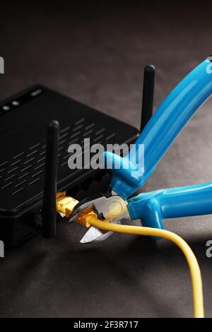 Cutting and disconnecting the network Internet connection with cutting pliers. Disabling the Wi-Fi router network. Life without internet. Disconnectio Stock Photo
