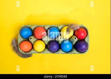 Multi-colored Easter eggs in an egg tray. Minimal concept. Card with copy space for text Stock Photo