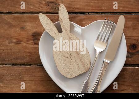 Easter table overhead view with a rabbit shape on a plate with cutlery Stock Photo