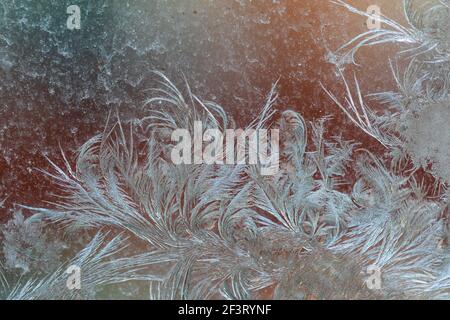 Jack Frost etchings on the window, with a colourful background. Stock Photo