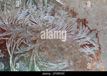 Jack Frost etchings on the window, with a colourful background. Stock Photo