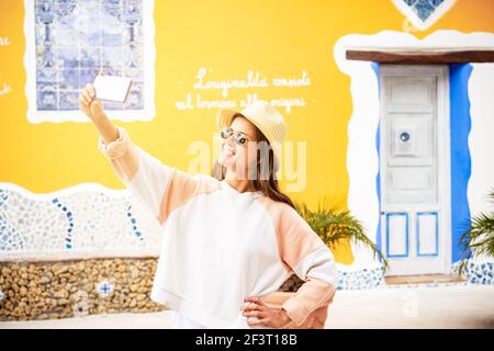 young tourist girl in place called Borgo Parrini Sicily takes a picture of herself smiling Stock Photo