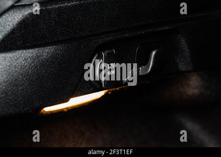 12V power charger plug inside car. Close up of the car cigarette lighter socket in modern car interior. Stock Photo