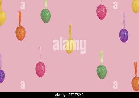 Creative Easter layout made of falling colorful eggs on light pink background. Minimal easter concept. Easter card with copy space for text. Stock Photo