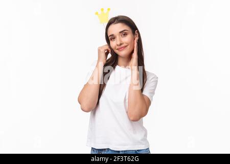Entertainment, fun and holidays concept. Portrait of beautiful and self-assured charming young smiling woman holding crown on stick near head, feel Stock Photo