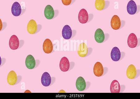 Trendy Easter pattern made of colorful eggs arranged on bright pink background. Minimal easter concept. Creative Easter card. Stock Photo