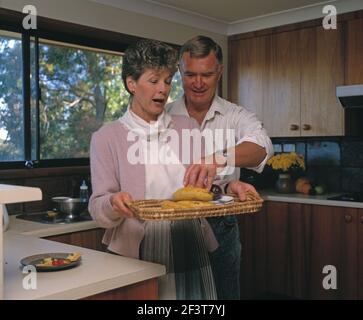 Australia. Man and woman in the kitchen with tray of fruit. Stock Photo