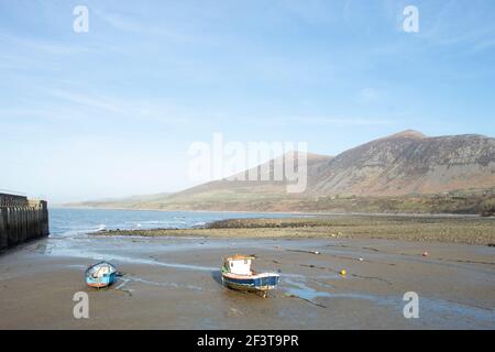 Trefor beach, Wales. Two small fishing boats at a secluded bay near Snowdonia on the Llyn Peninsula on a sunny, bright spring day. Peaceful placid cou Stock Photo