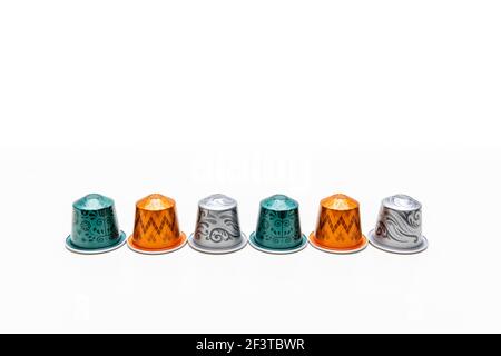 Six coffee capsules in line and isolated on a white background. New design. Free copy space for text. Stock Photo