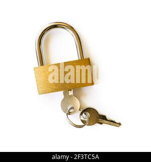 Closed padlock with keys isolated on white background. Locked yellow brass padlock closeup. The key is inserted into the lock. Access security concept Stock Photo