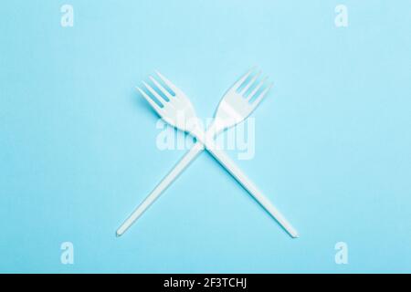 Plastic forks on a blue background. Plastic waste and pollution concept. Stock Photo