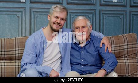 Happy bonding loving different male generations family of senior father and adult son or grandson Stock Photo