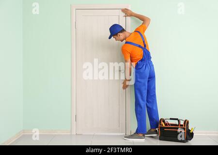 Construction worker repairing door indoors Stock Photo