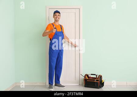 Worker showing thumb-up near door Stock Photo