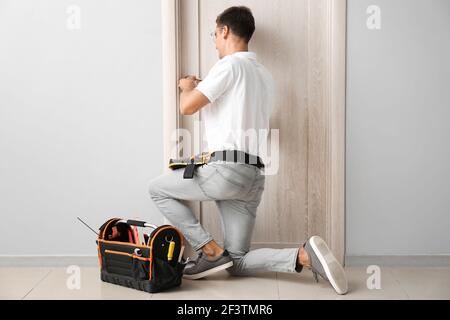 Construction worker repairing door indoors Stock Photo