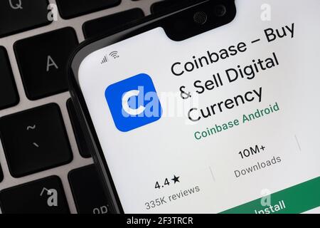 Coinbase app seen on the screen on smartphone which is placed on the laptop keyboard. Stafford, United Kingdom, March 14, 2021 Stock Photo