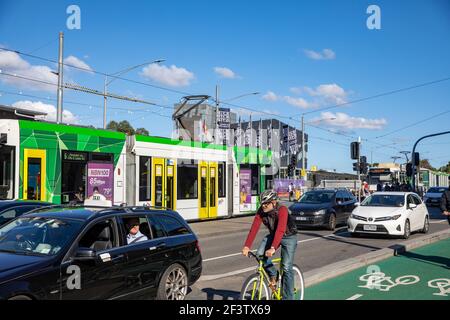 Melbourne tram on Princes bridge with cars commuting in traffic and male cyclist riding bicycle in the bike lane,Victoria,Australia Stock Photo