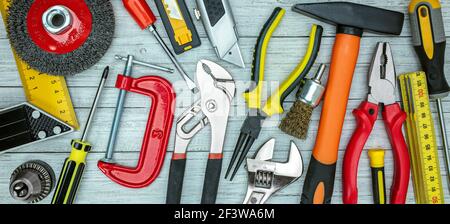 various working tools on grey table background. drills, wrenches, bolts, screws, clamps top view Stock Photo