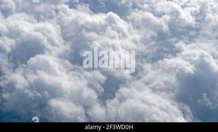 A cluster of large cumulus clouds, with tops pointing slightly to the right, an aerial shot taken at an altitude of ten thousand kilometers from the w Stock Photo