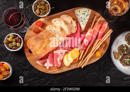 Italian food. Various antipasti, shot from the top on a black background Stock Photo