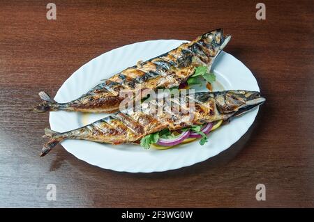Mackerel baked on the grill lies on a white plate Stock Photo