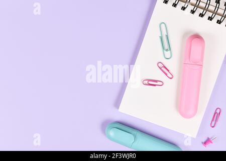 Clipboard with pink and blue text markers and paper clips on purple background with empty copy space Stock Photo