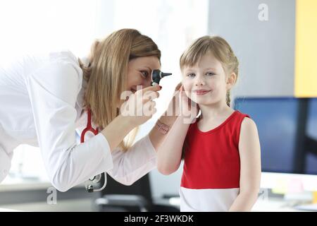 An otolaryngologist examines ear of little girl Stock Photo