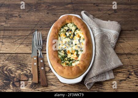 Open cheese pie with chard in Adjara style on the wooden table, top view. Delicious homemade food Stock Photo