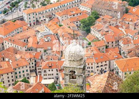 Looking down on terracotta tiled rooftops from the mountain path running above the historic ancient town,towards Kotor Fortress. Stock Photo