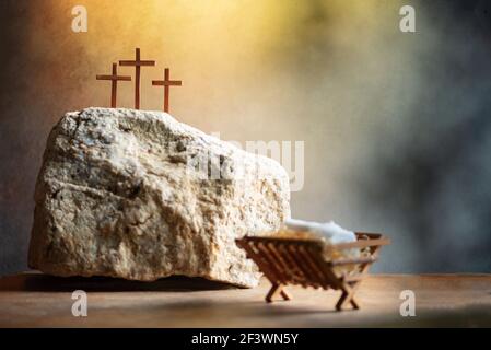 Christian Christmas, Easter concept. Born to Die, Born to Rise. Wooden manger, three crosses background. Jesus - reason for season. Salvation, Messiah Stock Photo