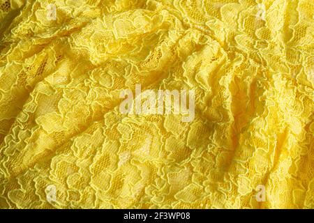 Yellow wrinkled modern fabric on the dress, macro. Stock Photo