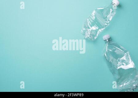 Empty rumpled used plastic bottle on blue background. Top view, copy space. Pollution, environmental protection concept. Reuse garbage, recycle Stock Photo