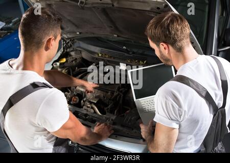 Working together on diagnostic problem in workshop Stock Photo