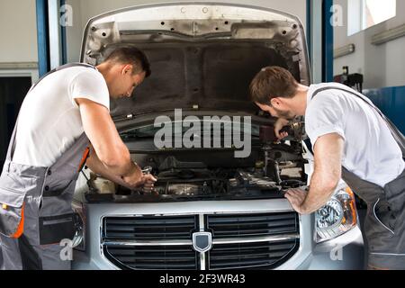 Team of mechanics working together in workshop Stock Photo