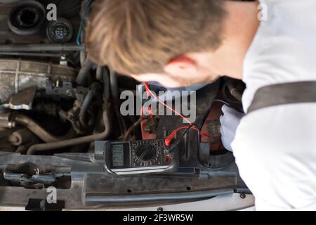 mechanic checks electronics accumulator with measuring equipment Stock Photo