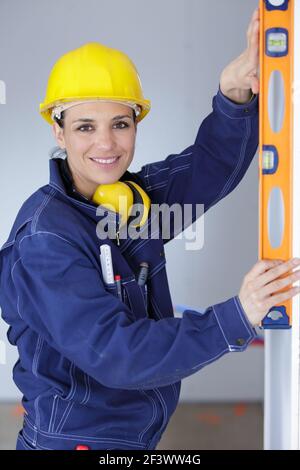 female builder using a spirit level Stock Photo