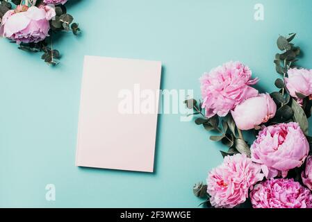 Background with rose flowers and empty notebook for text on wooden planks. Vertical. Place for text. Top view with copy space Stock Photo