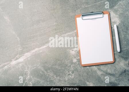 Top view of clipboard, paper, pen on marble background with copy space. Top view, copy space. Blogger, feminine business concept. Flat lay. Feminine Stock Photo