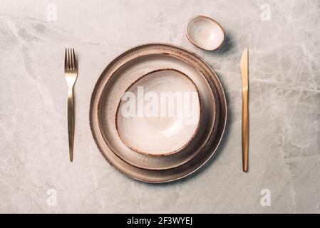 Stoneware plate setting with knife and fork on marble background. Top view. Copy space. Flat lay. Serving a festive table concept Stock Photo